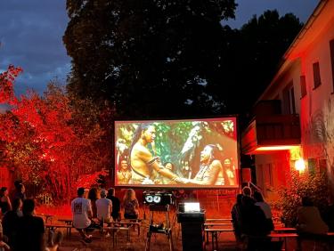 Open Air Cinema with red illuminated trees in the background