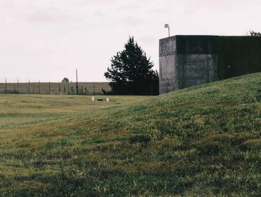 Image of grassy hill with bunker and fence